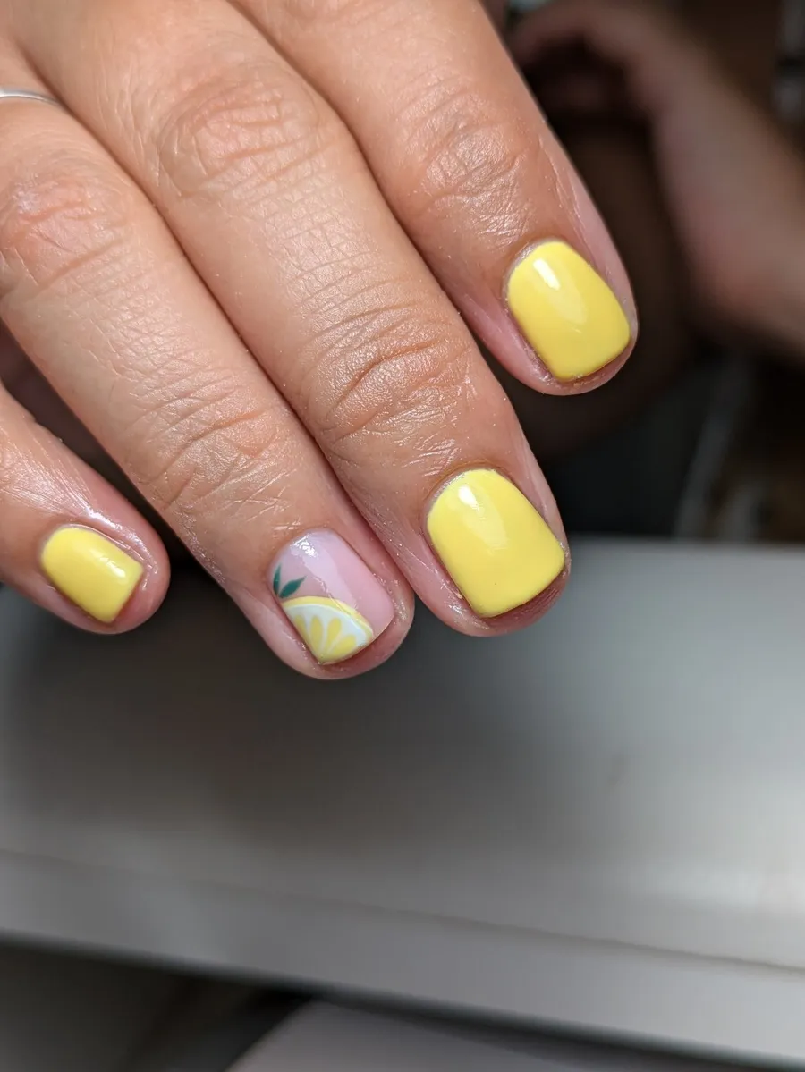 Manicura en amarillo pastel sobre uña corta
