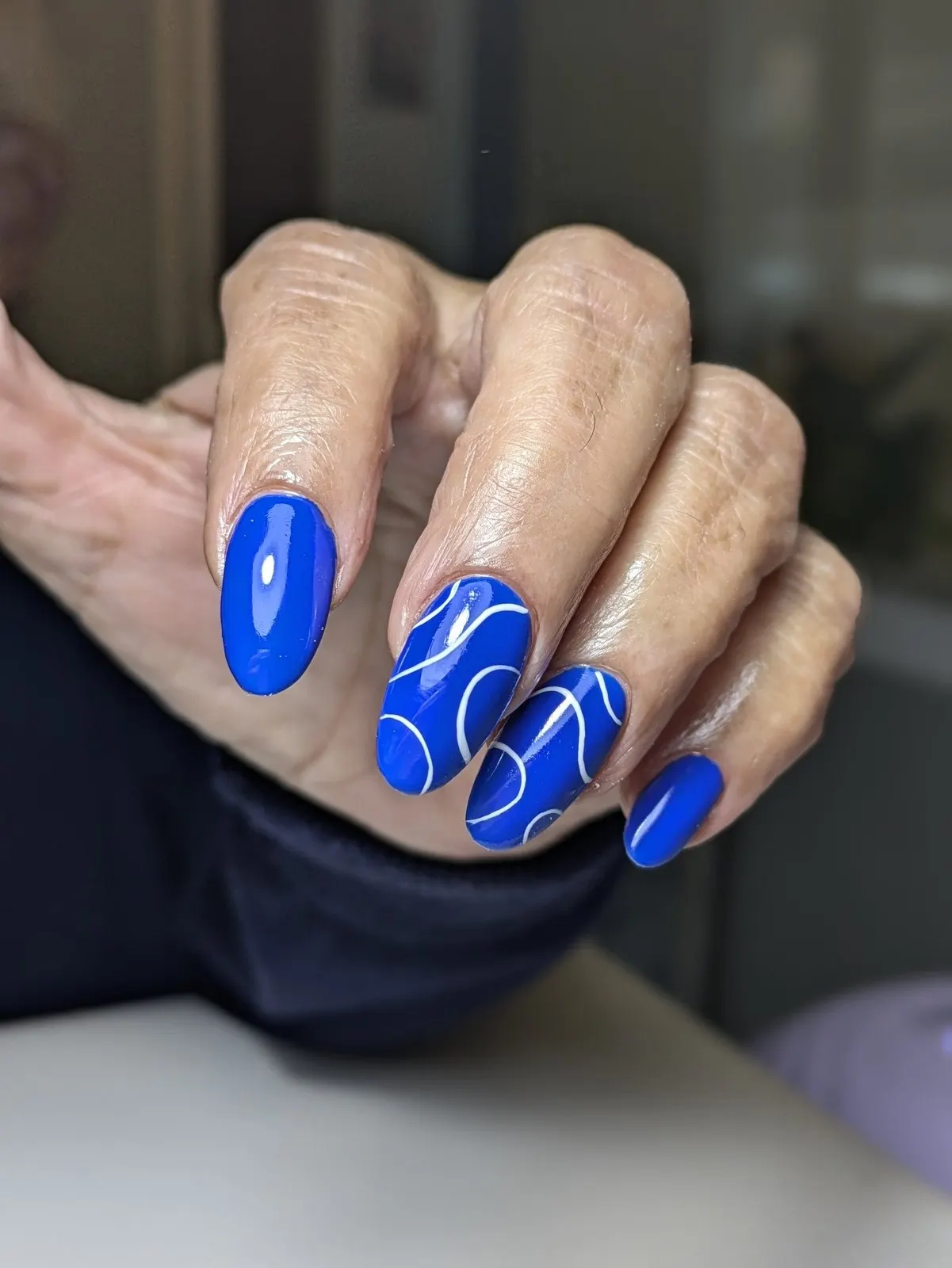 Manicura en azul intenso sobre uña larga almendrada