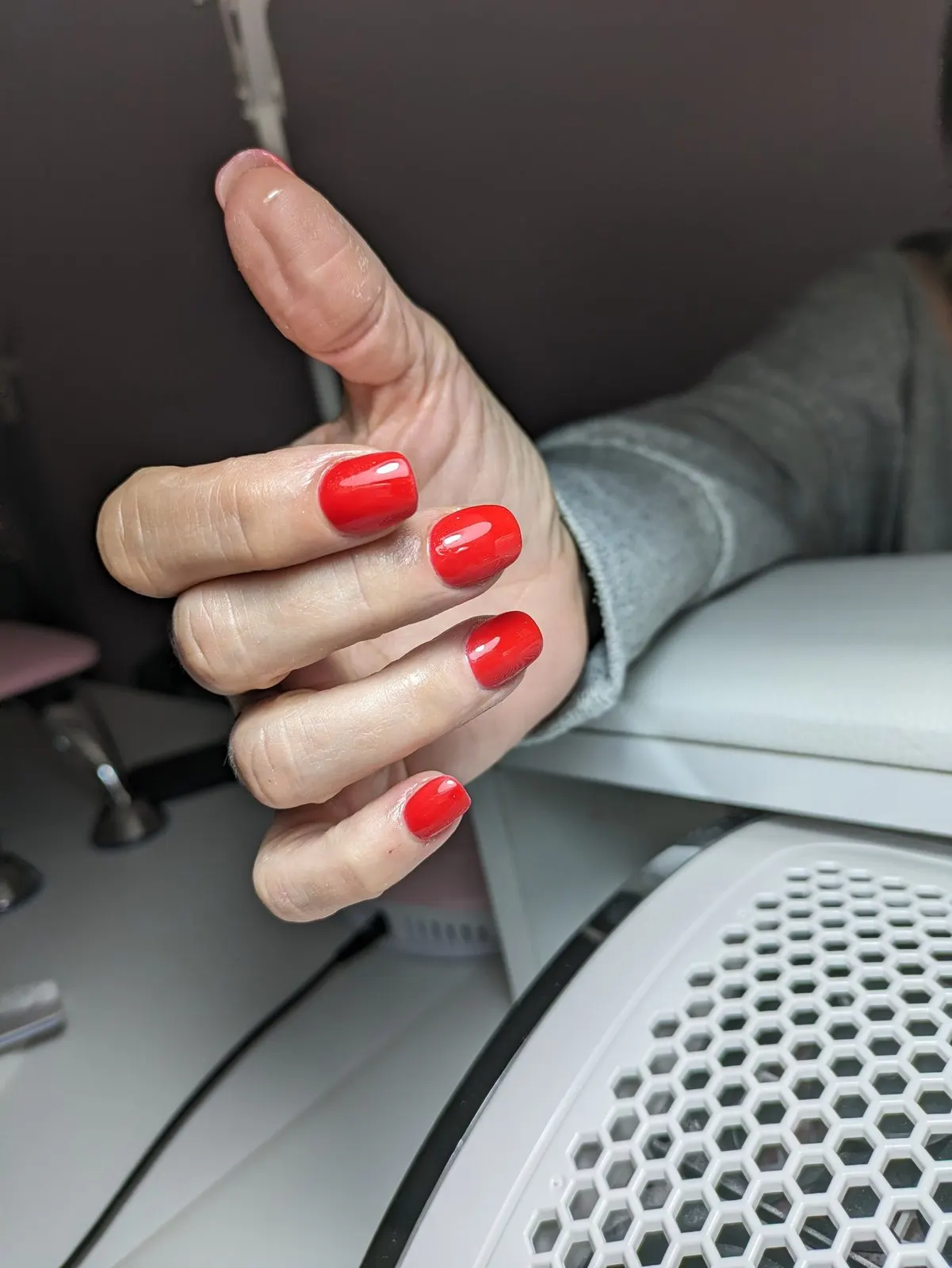 Manicura en rojo clásico sobre uña corta de forma ovalada
