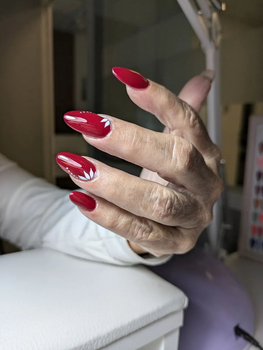 Manicura en rojo vino sobre uñas largas de forma almendrada